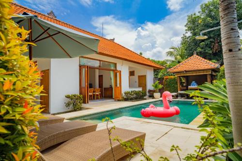 a pool in the backyard of a house with a pink rubber duck in a pool at Villa Seruni Lovina in Lovina