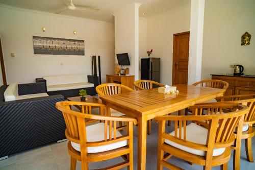 a dining room with a wooden table and chairs at Villa Seruni Lovina in Lovina