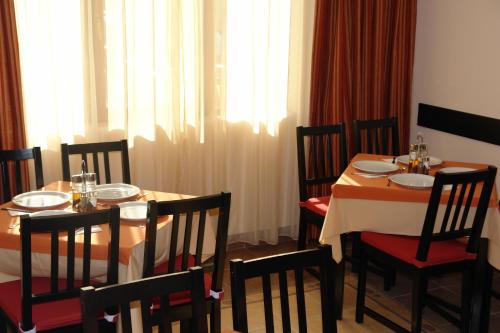 a dining room with a table and chairs and a window at Arion Hotel in Constanţa