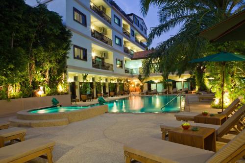 a hotel with a swimming pool in front of a building at Baan Souy Resort in Pattaya South