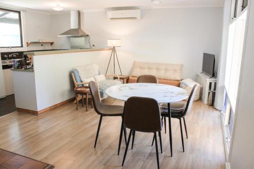 a living room with a table and chairs at Sandy Swell Beach Shack - Goolwa in Goolwa South