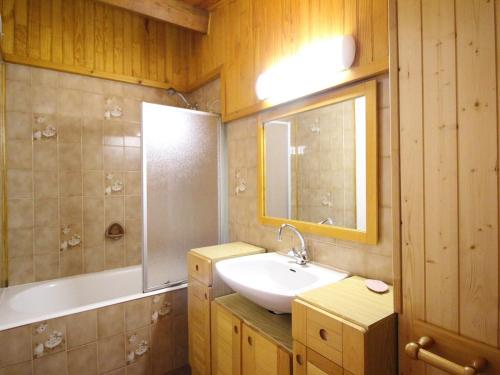 une salle de bain avec un lavabo, une baignoire et un miroir dans l'établissement Duplex centre Mont-Dore, 80m², terrasse, parking, 6 pers, no animaux - FR-1-415-130, à Le Mont-Dore
