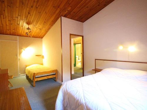 une chambre d'hôtel avec deux lits et un miroir dans l'établissement Duplex central 90m² avec parking, 2 chambres, 6 couchages, proche Thermes, wifi inclus - FR-1-415-136, à Le Mont-Dore