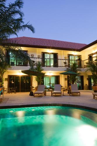 a hotel with a swimming pool in front of a building at Baan Souy Resort in Pattaya South