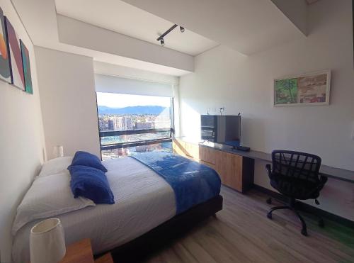 a bedroom with a bed and a desk and a window at AH/ Live‑Work Loft, Coworking, terraza, Gym, Chía in El Cerrito