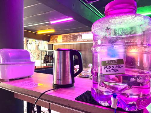 a bottle ofinking water sitting on a table next to a kettle at Here We Go Bangkok in Bangkok