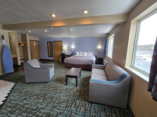 a hotel room with a bed and two couches at Quality Inn in Johnstown