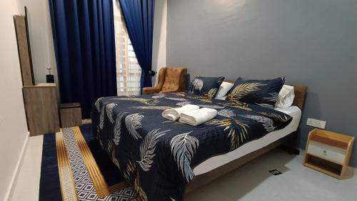 a bedroom with a bed with a blue comforter at Alam Perdana @ Kemaman Cukai in Cukai