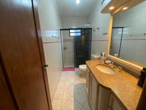 a bathroom with a sink and a toilet and a mirror at Imana Hostel in Florianópolis