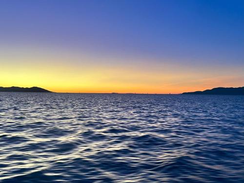 a view of a large body of water at sunset at Island Romance or Family & Pool in Nelly Bay