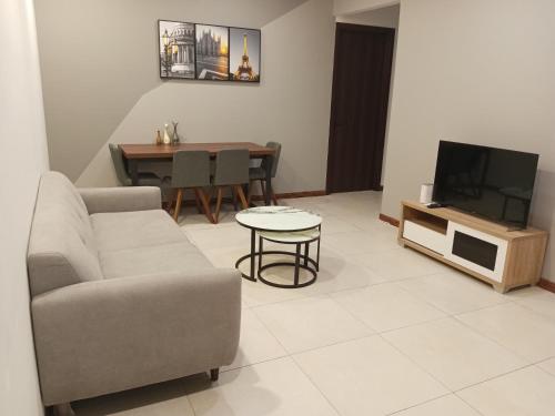 a living room with a couch and a tv and a table at Family Friendly Unit in K Avenue in Donggongon