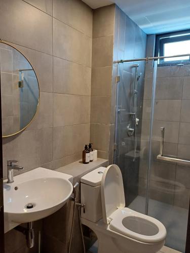 a bathroom with a toilet and a sink and a shower at Family Friendly Unit in K Avenue in Donggongon