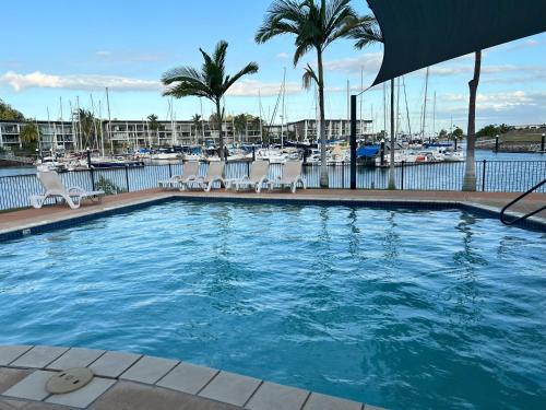 a large swimming pool with chairs and a marina at Island Romance or Family & Pool in Nelly Bay