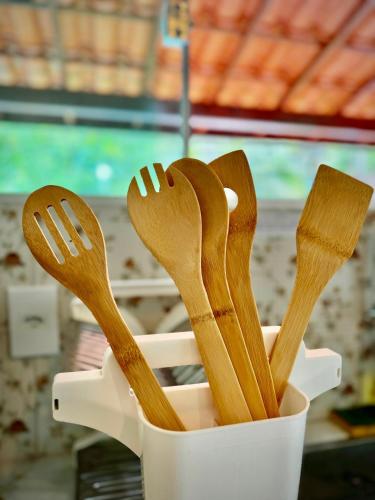 a plastic container filled with wooden spoons and spatulas at Canto da Iara in Ilha de Bolpeba