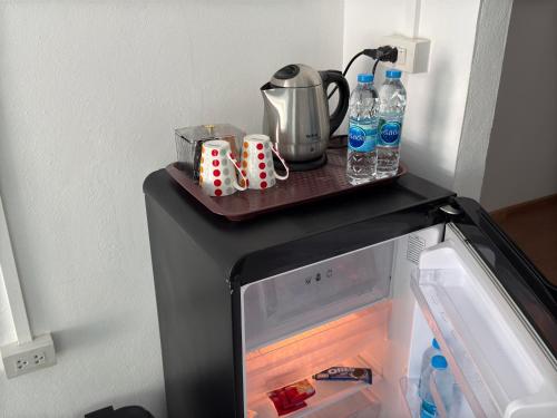 a small refrigerator with a tray on top of it at Mem Homestay in Ban Khlong Wang Chang