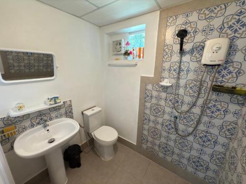 a bathroom with a shower and a sink and a toilet at Mem Homestay in Ban Khlong Wang Chang