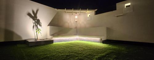 a room with a green lawn in the corner of a building at عريش ماجد بيت بالكامل Full House in As Suwayq