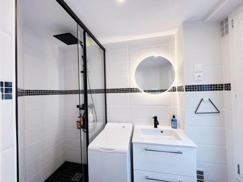 une salle de bain blanche avec un lavabo et une douche dans l'établissement Bastille Marais cosy citycenter, à Paris