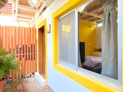 a room with a window and a bedroom with a bed at Frida Paradise Beach Hotel - Punta Zicatela in Brisas de Zicatela