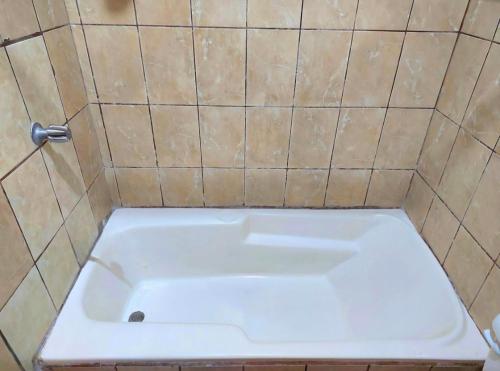 a white bath tub in a tiled bathroom at Casa del Pacífico en Puntarenas Centro con parqueo in Puntarenas