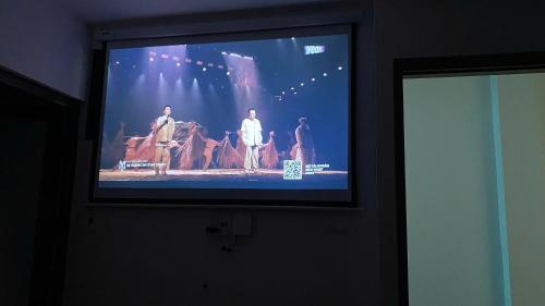 a flat screen tv with a group of people on it at Era Apartment - Chùa Láng in Hanoi