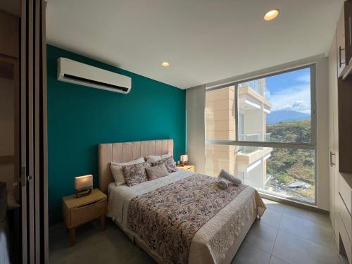 a bedroom with a bed and a large window at Edificio Salguero Suites in Santa Marta