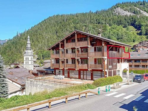 un grand bâtiment en bois sur le côté d'une rue dans l'établissement Studio cosy à La Clusaz - 3 pers, parking, Wifi, animaux admis - FR-1-818-85, à La Clusaz