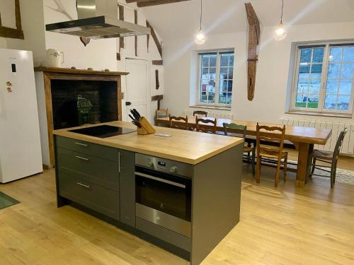 - une cuisine avec une cuisinière et une table dans une chambre dans l'établissement Grande maison familiale près d'Orléans, calme avec jardin - FR-1-590-563, à Loury