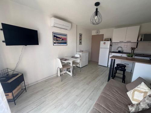 Il dispose d'une cuisine et d'un salon avec une table et un canapé. dans l'établissement Collioure T2 élégant avec terrasse et parking - FR-1-309-492, à Collioure