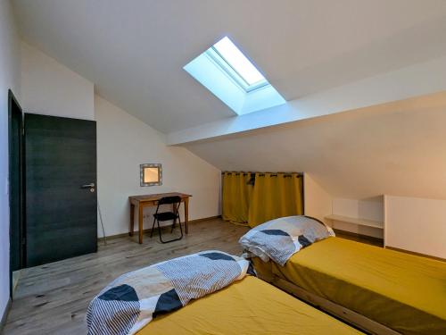 two beds in a room with a skylight at Appartement cosy, 2 chambres et parking privé, proche des Vosges - FR-1-589-780 in Saint-Michel-sur-Meurthe