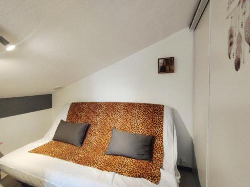 une chambre avec un lit avec deux oreillers dessus dans l'établissement Villa T2 Mezzanine - 6 Pers - Parking, Piscine, Clim - FR-1-795-55, à Fleury