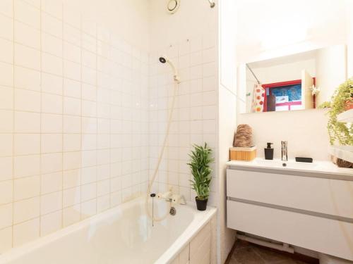 une salle de bain blanche avec une baignoire et un lavabo dans l'établissement Confort à St Lary: T2, 4 pers, jacuzzi, sauna, gym, parking - FR-1-296-512, à Vignec