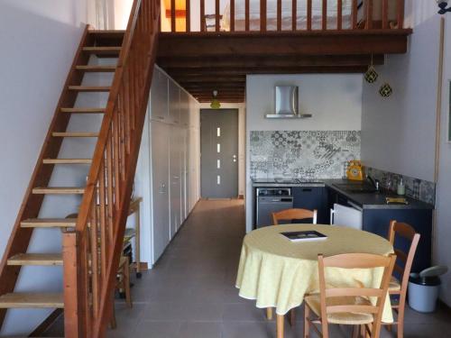 - une cuisine avec une table et un escalier dans une chambre dans l'établissement Maison rénovée 4 pers. avec jardin et PARKING - FR-1-738-34, à Saint-Georges-de-Didonne