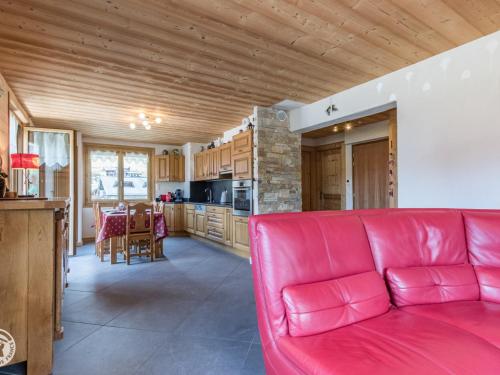 un salon avec un canapé rouge et une cuisine dans l'établissement Chalet cosy aux Gets avec parking privatif - FR-1-671-279, aux Gets