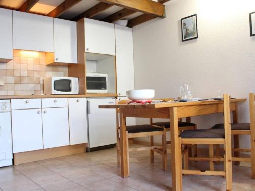 une cuisine avec des armoires blanches et une table en bois dans l'établissement Maison 5 pers. proche plage avec jardin, parking - FR-1-246A-333, à Dolus-d'Oléron
