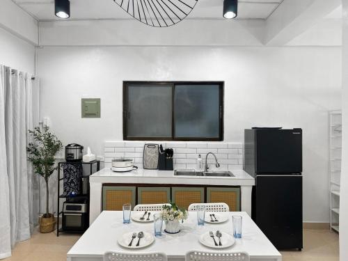 a kitchen with a table and a sink and a refrigerator at Family Apartment By The Beach with Kitchen Netflix Station 3 Beachfront in Boracay