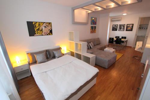 um quarto com uma grande cama branca e um sofá em New Belgrade apartment Neven, parking 5 evra dan em Belgrado