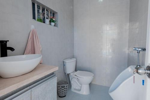 a white bathroom with a sink and a toilet at Casa campestre en punta canoa Cartagena in Punta Canoas