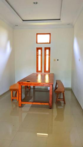 a wooden table in a room with a chair at Wisma KLG 1 in Kaliurang