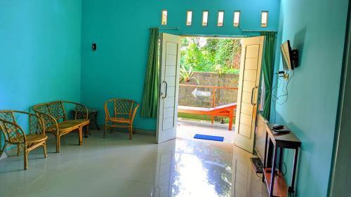 a hallway with chairs and a door to a patio at Wisma KLG 1 in Kaliurang