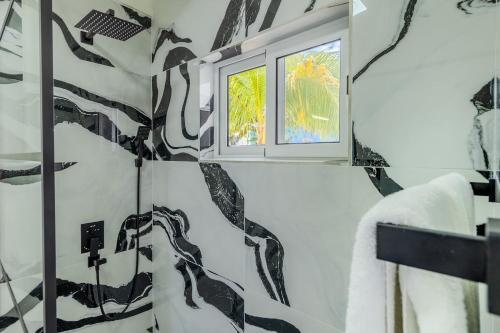 a bathroom with a window and a black and white wall at 5 minutes to Eagle Beach Blue Lagoon by Bocobay in Palm-Eagle Beach