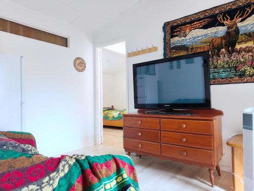 a living room with a flat screen tv on a dresser at Private 1 bedroom Guestsuite Step Away of Sunnynook Central in Auckland