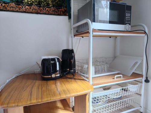 a microwave sitting on top of a wooden table at Private 1 bedroom Guestsuite Step Away of Sunnynook Central in Auckland