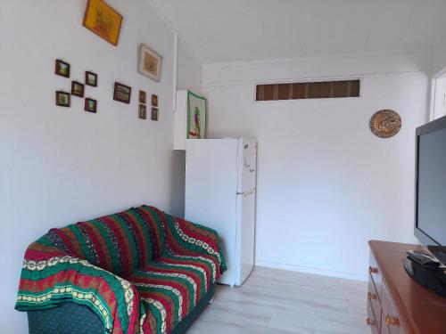 a living room with a couch and a refrigerator at Private 1 bedroom Guestsuite Step Away of Sunnynook Central in Auckland