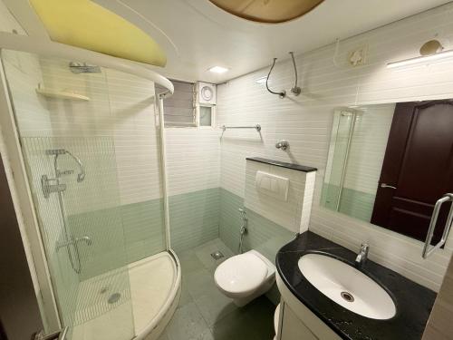 a bathroom with a sink and a shower and a toilet at Lake View Castle in Trivandrum