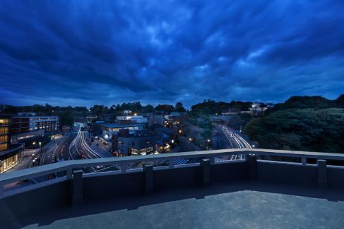 a view of a city from a bridge at night at HOTEL AO Kanazawa in Kanazawa