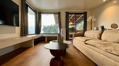 a living room with a couch and a table at Tantawan sea view residence 山海居 in Salad Beach