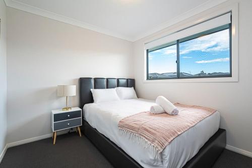 una camera da letto con un letto grande e una finestra di Leppington 5Br house near train and shopping a Leppington