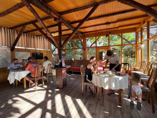 a group of people sitting at tables in a restaurant at Happy Nomads - Modern Yurt Cottages & Breakfast in Karakol