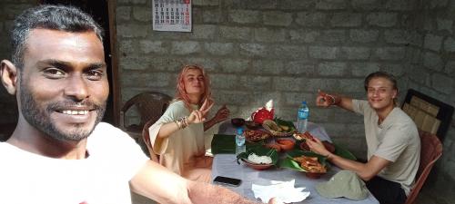 a group of people sitting at a table eating food at Rana Treehouse in Piduragala